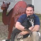 Andrew Carroll kneeling and holding dog