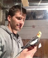 Ivo Ros with a cockatiel perched on finger